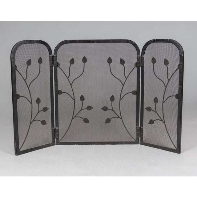 Vintage American wrought iron three-panel folding fireplace screen decorated with free form vines and foliage. The mesh...