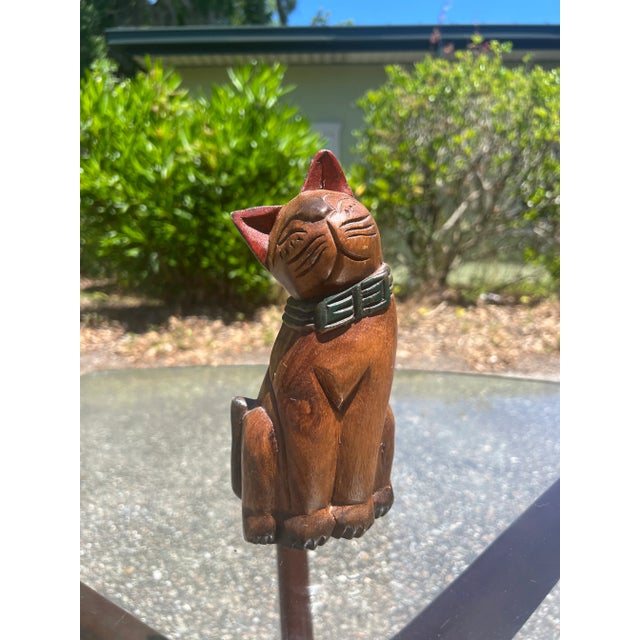 Vintage Hand Carved and Painted Wooden Cat Statue Folk Art Sitting Smiling Cat. Circa mid-20th century. Cat is wearing an...