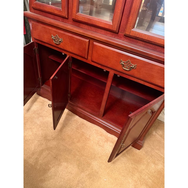 This elegant hutch has a rich reddish brown finish. This two-piece Hutch features a rear mirror, a top section with three...