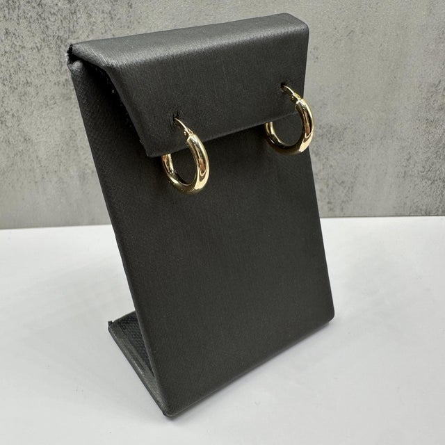 These classic hoop earrings in 14kt yellow gold feature a polished, timeless design perfect for everyday wear. Measuring...