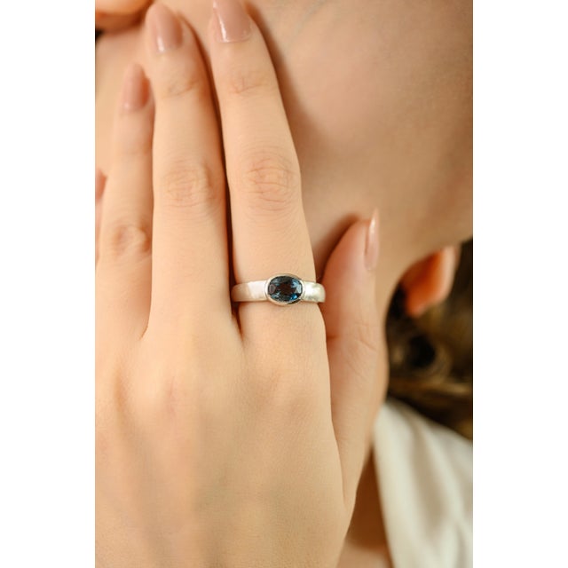 Crafted in high-quality 925 sterling silver, this elegant band ring features a stunning east west set london blue topaz...