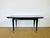 An elegant rectangular dining table dating from the 1940s-1950s, featuring a stunning Macassar veneer top with a rich,...