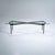 Rectangular coffee table featuring a clear glass top resting on an x-shaped black iron frame. The table stands on straight...