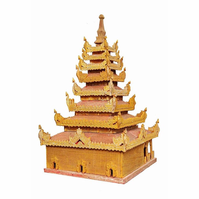 A hand carved miniature Thai temple in wood, painted gold and red with finely carved details. A model for a temple of the...