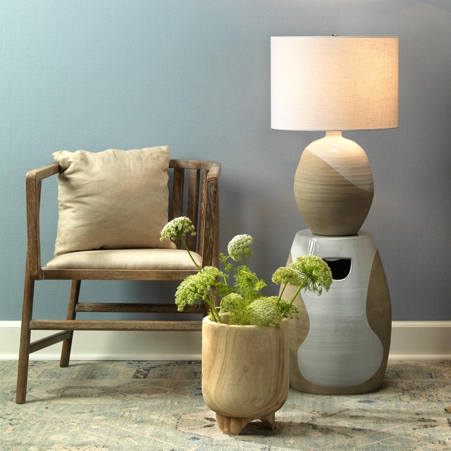 An intriguing addition to virtually any décor, this artisan made ceramic vase is topped with a white linen drum shade and...