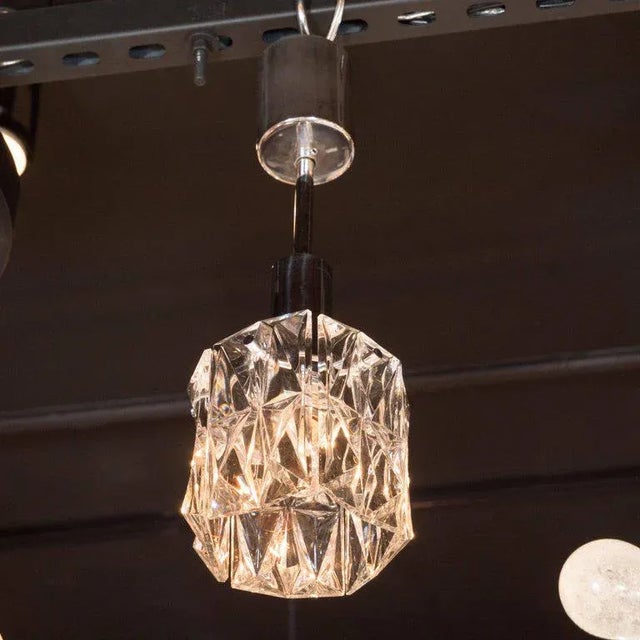 This sophisticated Mid-Century Modern pendant features a single glass shade replete with an abundance of raised geometric...