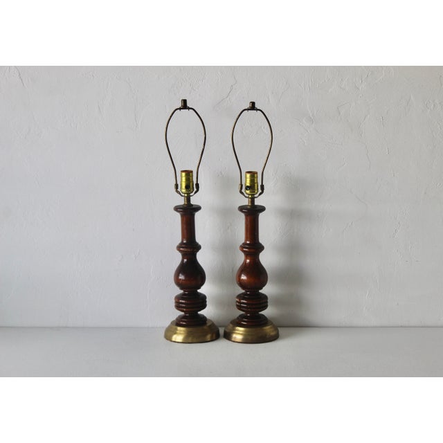 Pair of vintage Mid-century turned wood table lamps with brass finish bases. In good vintage condition with lots of wear...