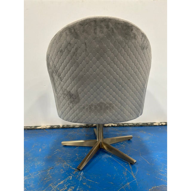 Stylish Caracole Modern Swivel Chairs. Pale brass base, curved body. Upholstered. Showroom floor sample.