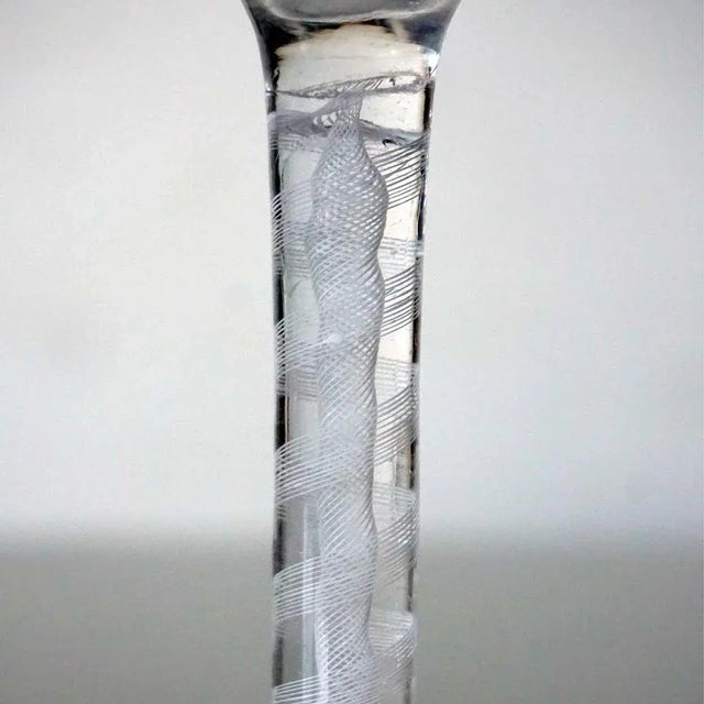 Found in Scandinavia, this antique twist stem glass displays an ogee bowl on a double-series white opaque twist stem, with...
