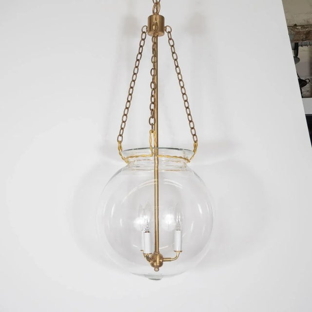 "Fishbowl" glass and brass pendant with wrought details. Creator: Marcelo Bessa Manufacturer: Spark Interior Origin:...