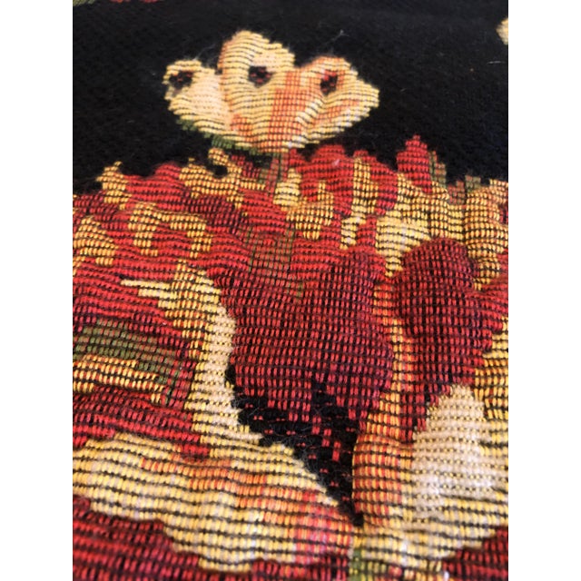 A striking French tapestry having black background and gorgeous rich floral in gold, blue, pink and green. There's a rod...