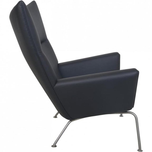 Hans wegner ch445 wing chair, upholstered in black bizon semi-anilin leather, and with a frame of steel. The chair is from...