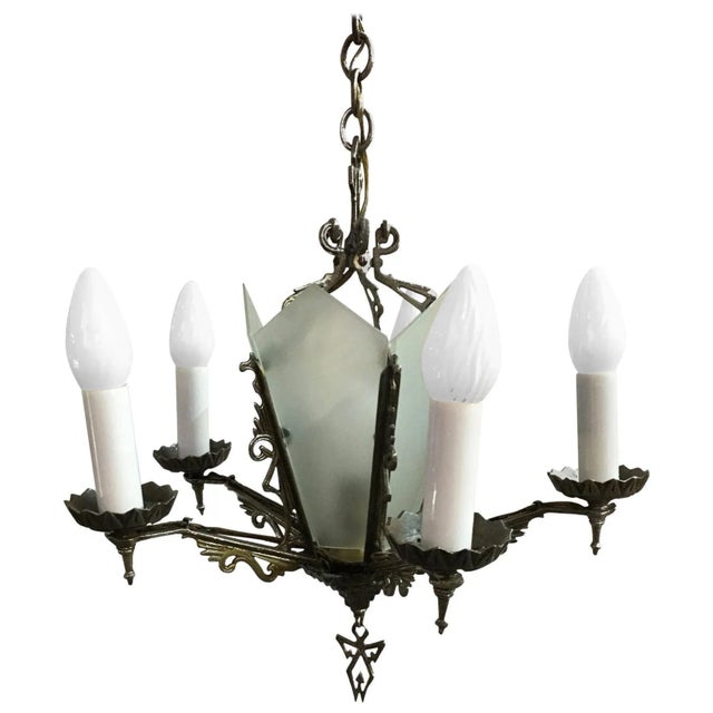 Five-arm geometric Art Deco chandelier with candle-style lights and a light-up slat glass center. The piece features...