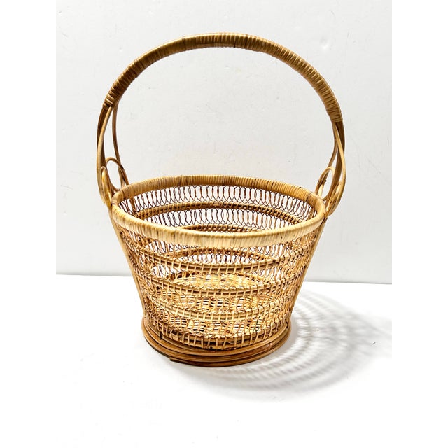 A beautifully crafted vintage bentwood wicker gathering basket featuring intricate openwork weaving and sculptural...