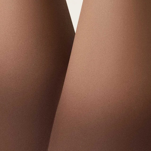 Resembling an island, a circular surface stays on two massive cone legs. The colors become more intense descending toward...