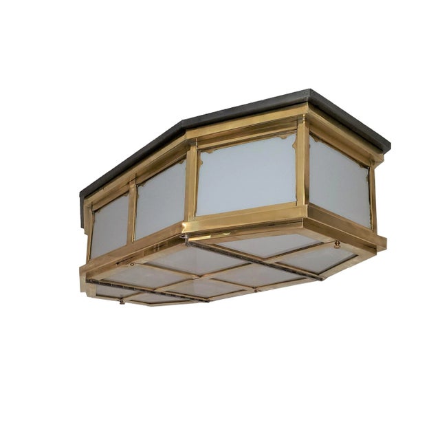 An elongated octagonal Mid Century Modern glass flush mounted fixture with stepped design brass frame. The eight sided...