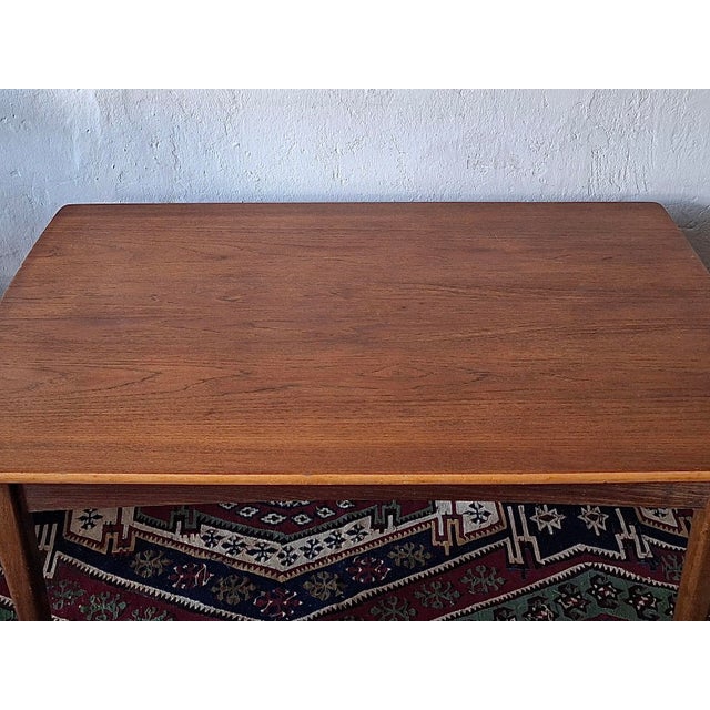 Teak dining table with a curved top and two 45 cm extension leaves, Denmark 1960s. The length is 125 cm when closed, 215...