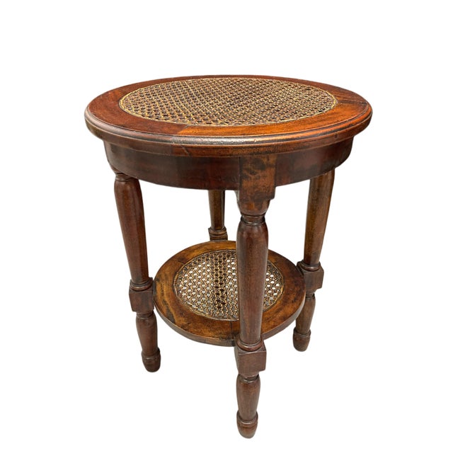 A beautifully crafted two-tier round accent table featuring handwoven cane insets, made in Indonesia in the late 20th...