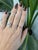 A 0.63-carat padparadscha sapphire oval sits at the centre of this solid 14K white gold ring, framed by eight earth-mined...