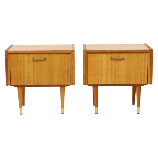 A lovely pair of vintage design nightstands, crafted from light-colored wood veneer and pine, featuring metal handles and...