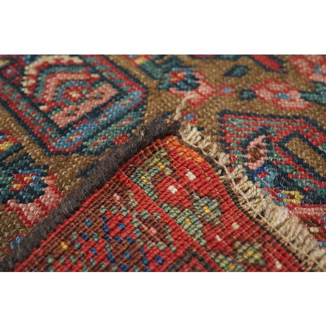 The coral tan field shows yen reversing, offset rows of geometric botehs. Red main strip style border with reversing...