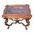 Elegant 1920 heavily carved display serving table featuring a raised angel relief beneath a glass top. The scalloped...