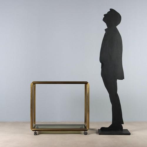 Double-tier service trolley, brass-plated metal and smoked glass. This piece is attributed to the mentioned...