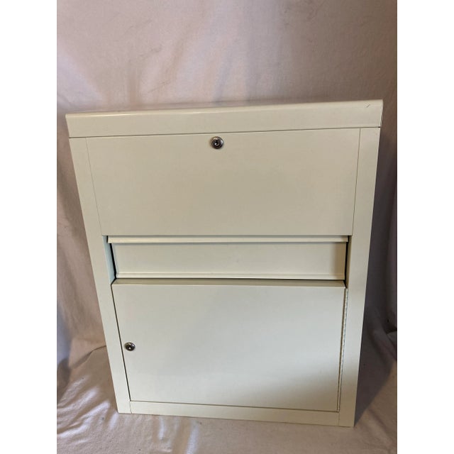 Nice locking medical cabinet with deep well on lid that lifts and also locks. Has pull out drawer and also bottom section...