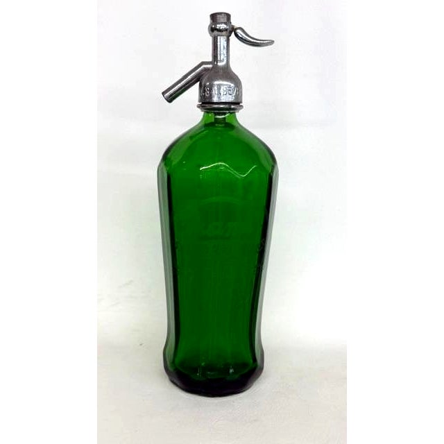 This gorgeous Seltzer Bottle is made out of paneled glass with a metal topper. This piece has brilliant Art Deco style to...