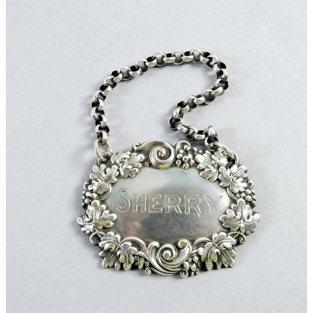 Vintage silver over copper hanging liquor tag engraved Sherry. Grape and grape leaf repousse design, marked Ster., however...