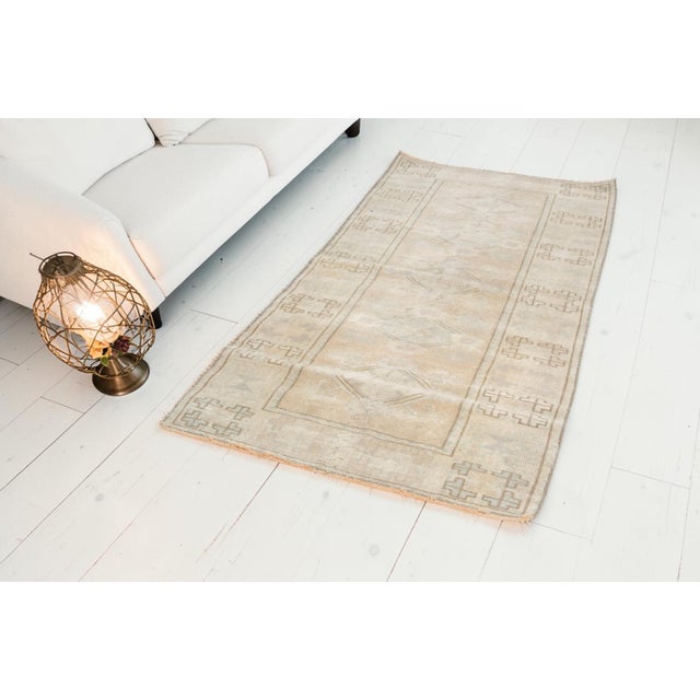 This is a vintage Turkish Oushak rug from the Mid 20th Century. The piece was hand-knotted.