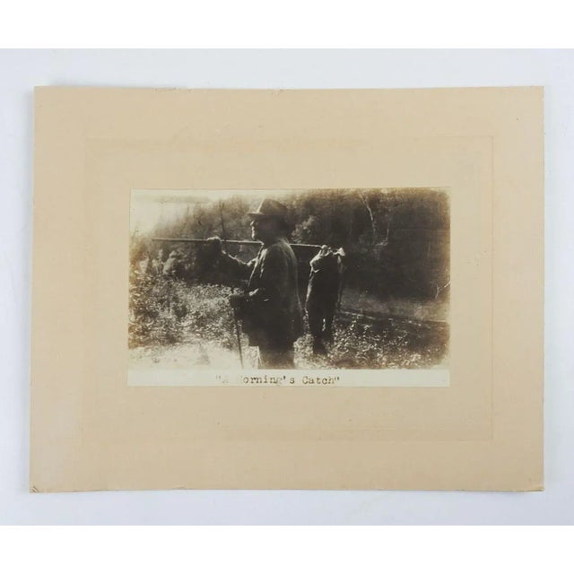 Vintage silver gelatin photograph of man with fish. Titled in plate "A Mornings Catch", unsigned. Unframed, mounted on tan...