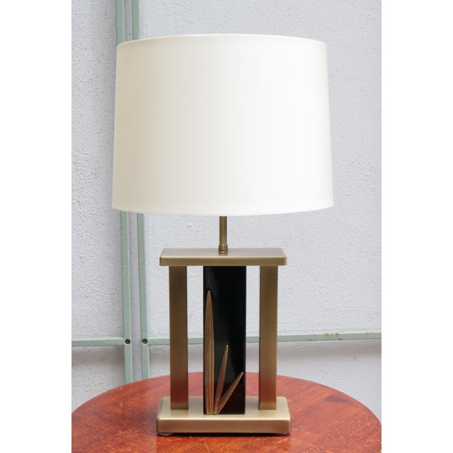 Single Italian Modernist table lamp. Brass frame with central enamelled metal column with brass leaf motif details.