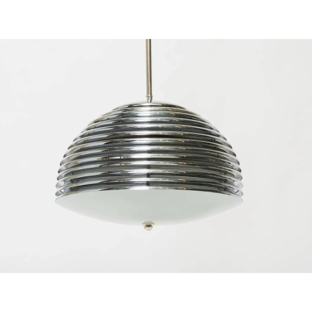Nickel-plated pendant light composed of overlaid metal disks with frosted convex glass bottom. Chandelier has been...