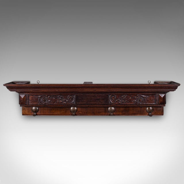 This is an antique reception hall coat rack. An English, stained pine four hook wall-mounted cloakroom valet, dating to...