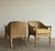 A handsome pair of McGuire club chairs with sculpted barrel backs caned on both the inside and the outside — a labor-...