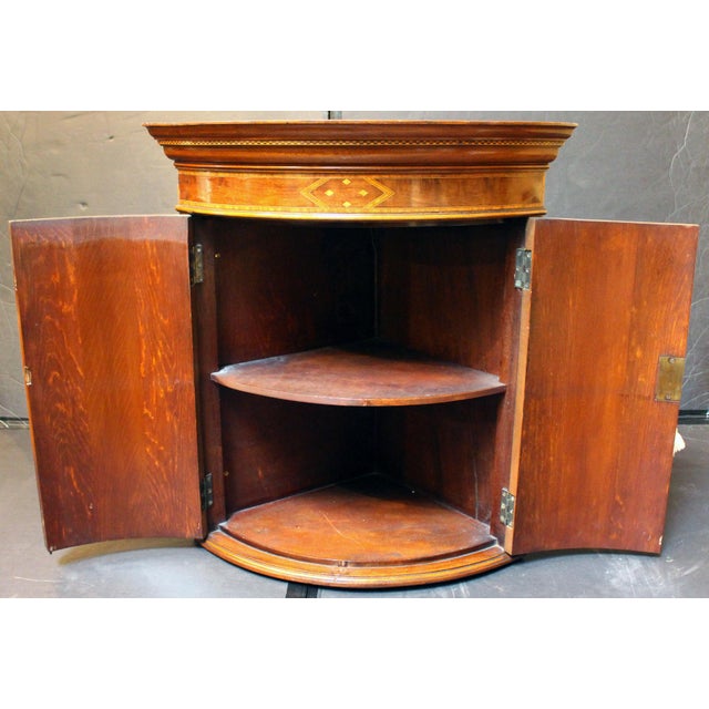 Late 19th century bowfront hanging corner cabinet, English. Sheraton revival. Mahogany & mahogany veneers with highly...