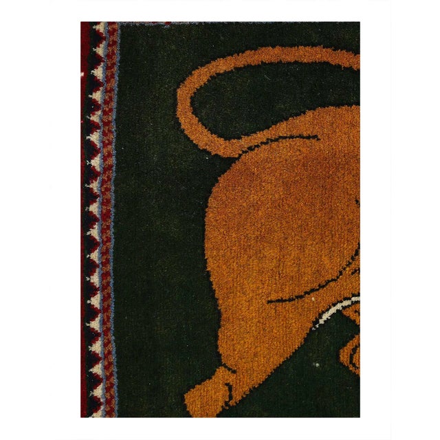 A unique Persian Shiraz small throw rug handmade with a pictorial design of a male lion in brown over a green background.