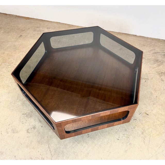 A fabulous 1970’s Lane hexagonal coffee table featuring beautiful walnut veneer, smoked glass top, contrasting black...