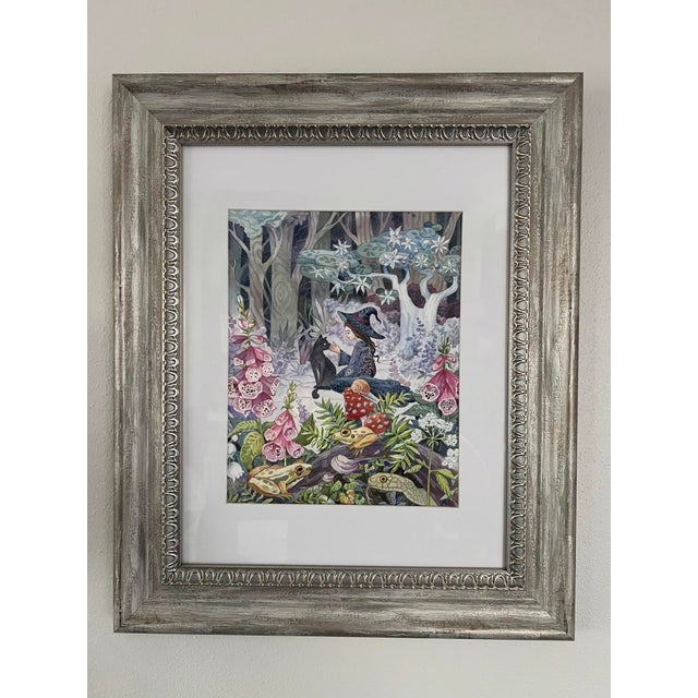 In "Foxglove," a serene woodland scene unfolds, where a witch gently interacts with a black cat amidst a lush tapestry of...