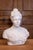 An Italian bust of a woman wearing a sleeveless and creased dress attached with a fibula. This elegant 20th-century...