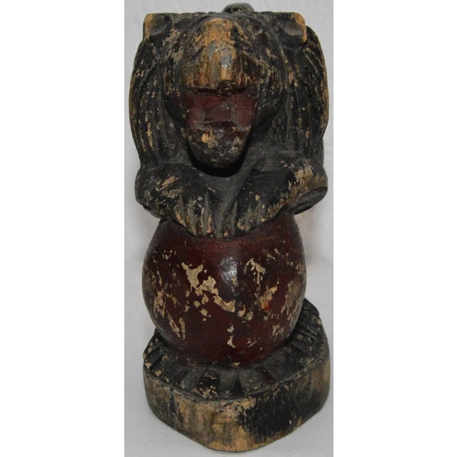 This is a unique early 19th century wooden carving depicting a stylized lion in black distressed paint, posed rampant on a...