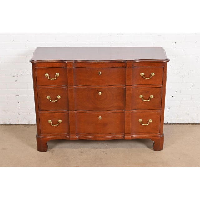 A gorgeous Georgian or Chippendale style three-drawer dresser, chest of drawers, or commode In the manner of Baker...