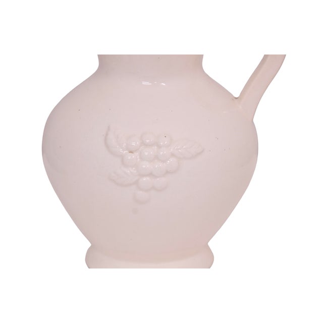 Vintage ivory ceramic seven inch farmhouse style pitcher vase with a raised high relief grape and leaf design. No maker's...
