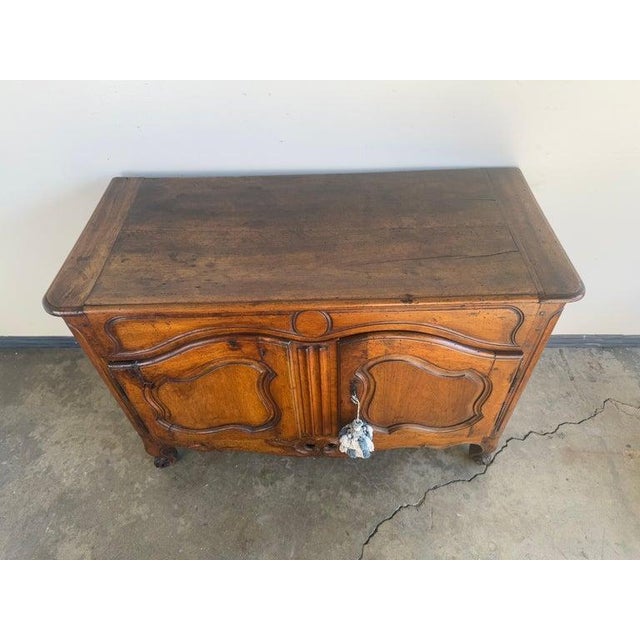 A beautifully proportioned 18th-century French provincial buffet in solid walnut, distinguished by its elegant serpentine...