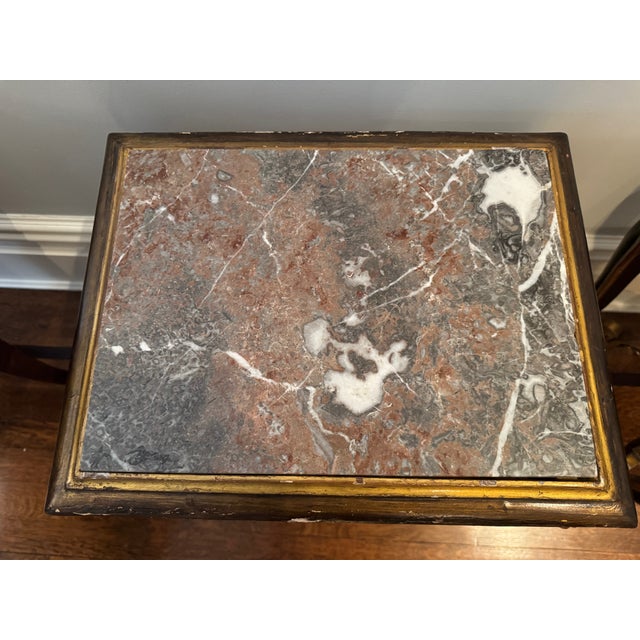 A striking pair of Rococo-style side tables from Paris, richly detailed with hand-carved ornamentation and warm gilt...