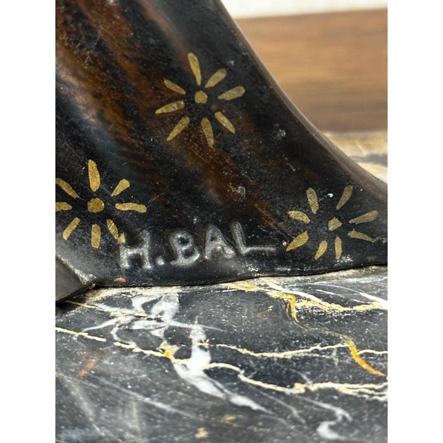 Charming Art Deco sculpture depicting an elegant young woman seated, holding a bird in her hand. The graceful movement,...