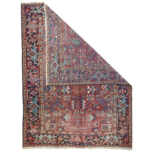 This Heriz/Mehriban large scatter/small carpet shows a red field dominated by a quartet of four curled ivory sawtooth...