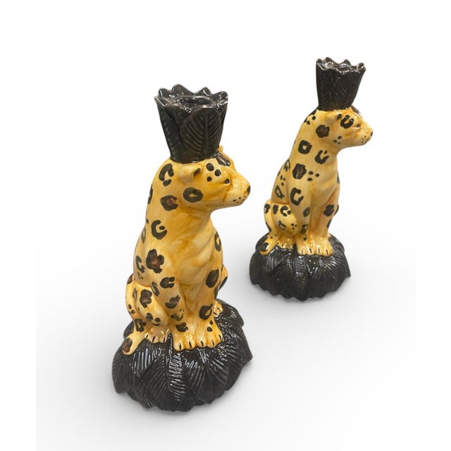 Hand-painted with a vibrant tawny glaze and classic black rosettes, each leopard sits poised atop a lush, dark-bronze-...