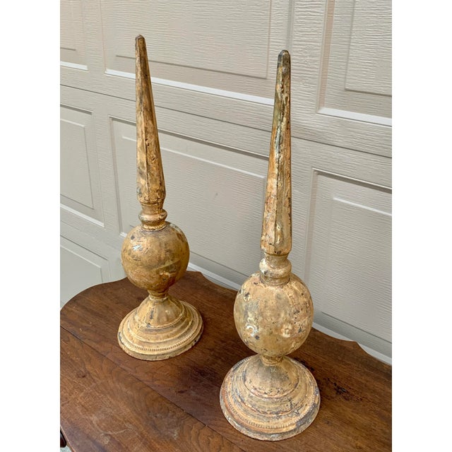 A striking pair of weathered cast iron garden finials with a beautifully aged surface and timeless architectural presence....